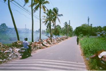 motorcycle on road with trash at roadside